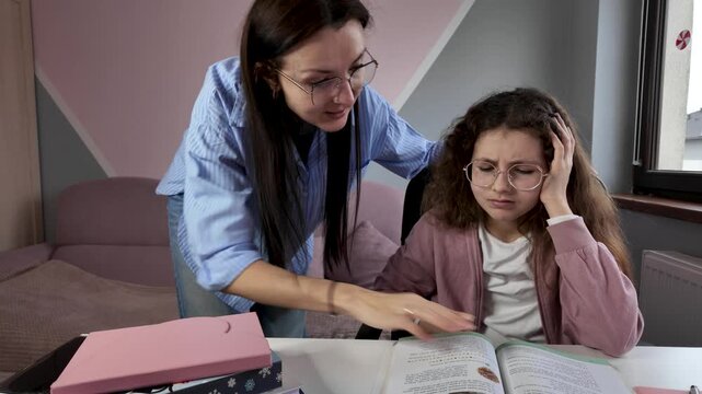 Mother emotionally explains homework to frustrated schoolgirl at home