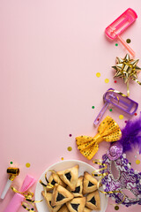 Vibrant vertical Purim scene featuring masks, confetti, hamantaschen, and festive party props on a...