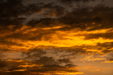 Obraz premium Sunset with orange and dark clouds seen over a horizon during the evening hours