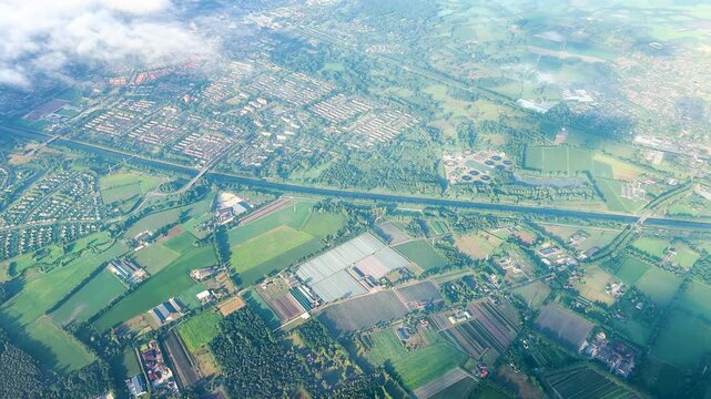 Homes and roads are scattered among dense green forest seen from airplane. . High quality 4k footage