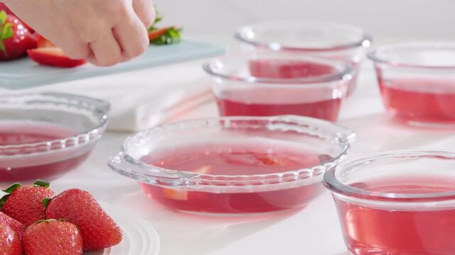 ssliced strawberries with the dissolved gelatin mixture. High quality 4k footage
