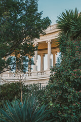 Fototapeta premium Majestic neoclassical architecture surrounded by lush greenery at sunset