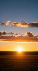Obraz premium Beautiful background image of a golden sunrise illuminating a vast open landscape and fluffy clouds above the horizon line at morning, orange, blank, template