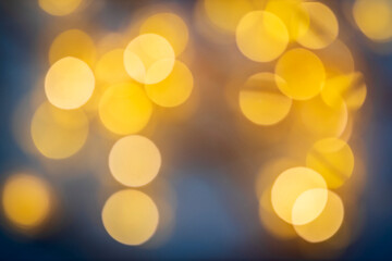 Fototapeta premium Soft golden bokeh lights background with warm blurred circles, festive atmosphere.
