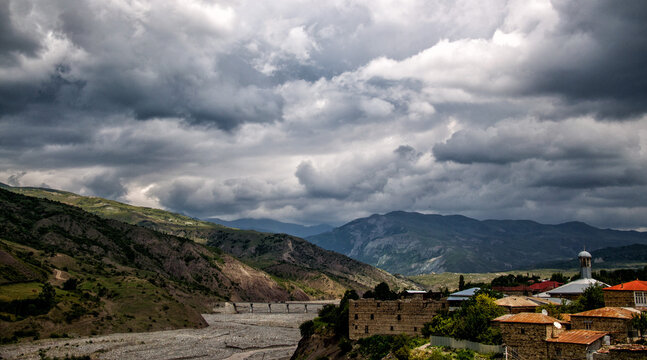 Ancient Lahij village in Azerbaijan nestled in the Caucasus Mountains. Traditional stone houses, river valley and dramatic cloudy sky. Cultural heritage destination and authentic travel experience in 