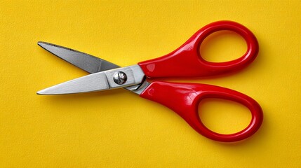 Open red plastic scissors positioned at a 35-degree angle on a bright yellow background, featuring a shorter left blade and a longer right blade, captured from a clean top-down perspective