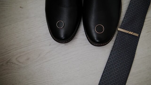 Men's wedding accessories are laid out on the floor in a beautiful arrangement