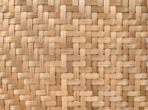 Background of natural woven bamboo texture with a dense pattern. Plain woven pattern is a traditional, environmentally friendly craft. Woven bamboo is finished with a polish for a glossy effect.