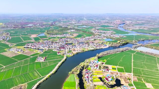 Aerial View of Rural Villages Along Winding River Valley with Green Fields