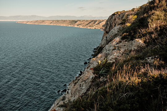Mediterranean coastline cliff and sea at sunset in Sardinia Italy