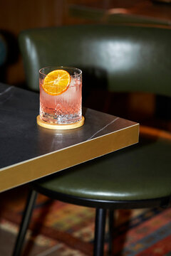 Cocktail with an orange slice in an elegant bar setting
