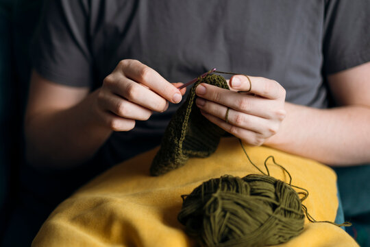 Person crocheting with green yarn and needle