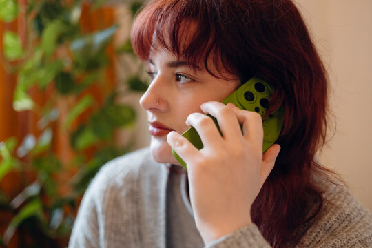 Teenager girl conversing on smartphone indoors