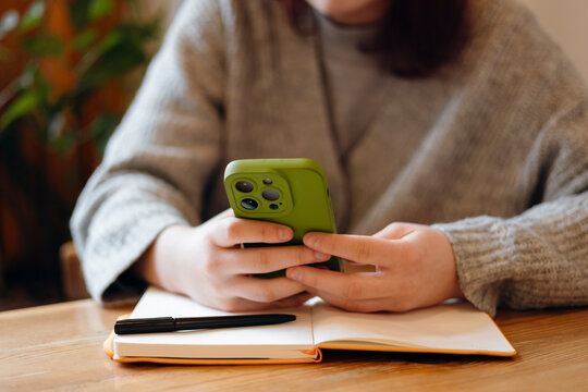 Teenager focused on smartphone while studying