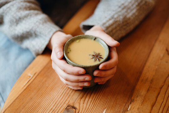 Teenage girl savoring a warm drink in cozy cafe