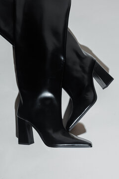 Elegant black leather boots on white background
