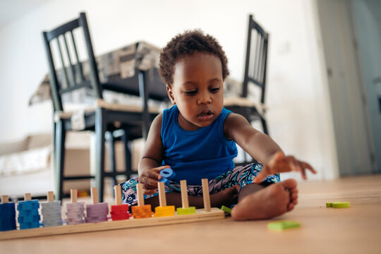Young child playing with educational wooden toy indoors