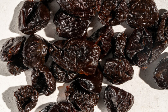 Close up of dried prunes on a textured surface