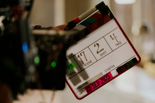 Film clapperboard on movie set with camera in background