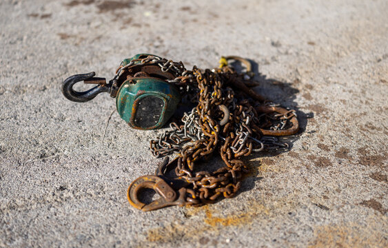 Rusty chain and hook on concrete surface
