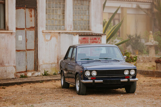 Vintage car parked beside an old building