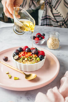 Pouring Agave or Maple Syrup over a Red Berry Yogurt Bowl