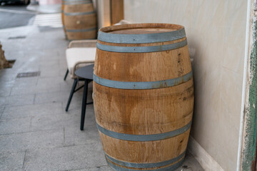 Fototapeta premium Wooden wine barrel outside cafe or winery on street