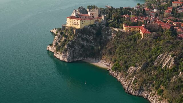 Duino Castle Italy Aerial Static View: Medieval Fortress on Steep Cliffs with Small Hidden Beach, Adriatic Sea Coastline near Trieste, Cinematic Mediterranean Aesthetics Drone 4K Footage
