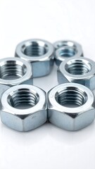 Seven silver-colored hex nuts arranged in a circle on a white reflective surface