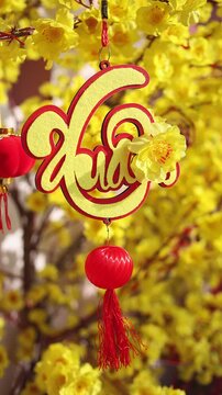 Colorful red and golden decorative elements sold on an vietnamese street market prior to the Tet holiday or Lunar new year in Vietnam, Asia. Vertical selective focus close up video.