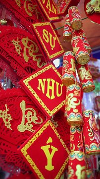 Colorful red and golden decorative elements sold on an vietnamese street market prior to the Tet holiday or Lunar new year in Vietnam, Asia. Vertical selective focus close up video.