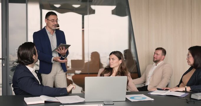 Diverse team members discussing business strategy during group meeting in office, reviewing data, brainstorming solutions, exchanging ideas, engage in collaborative decision-making, project planning