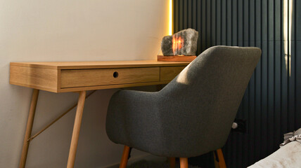 Modern wooden desk with a comfortable armchair and a unique salt lamp