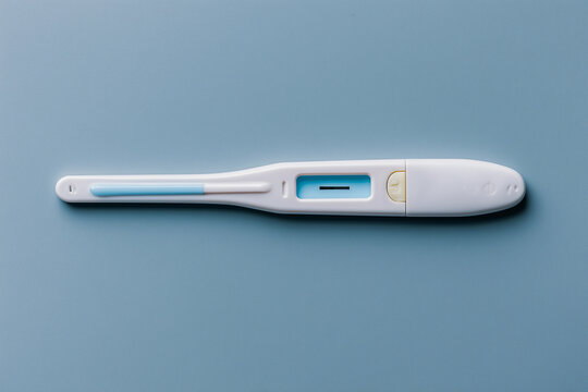 Confirmation test device on a blue surface used for checking pregnancy and monitoring fertility status in home settings