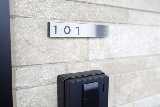 集合住宅の玄関に設置された部屋番号101の金属プレート。
