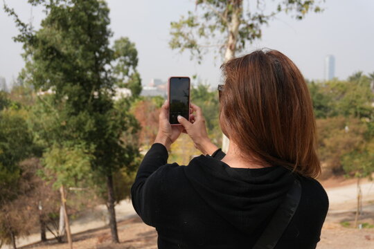 Mujer sacando fotos a paisaje con celular