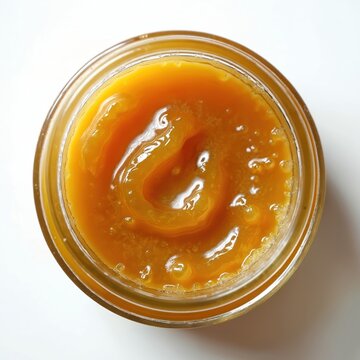 Orange cannabis concentrate in glass jar. Sticky oil wax budder shatter for medical use. Macro closeup of golden terpene rich extract. Legal hemp product detail. THC CBD.