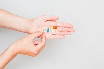 A woman hand take pills from the palm of his hand to take painkillers, medicines, vitamins or antibiotics. Health concept. Pharmacological preparations, medicinal products.