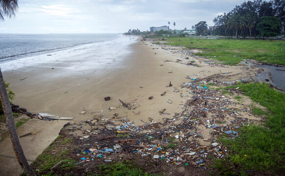 white sand beach polluted with plastic bottles and trash