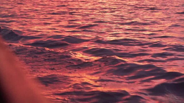 A slow-motion view of a tranquil lake during a vibrant sunset