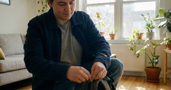 Man inspecting backpack indoors daylight