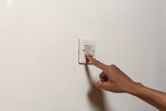 Close-up hand flips a wall light switch on and off, producing dry, sharp plastic clicks with a firm snap from finger pressure.