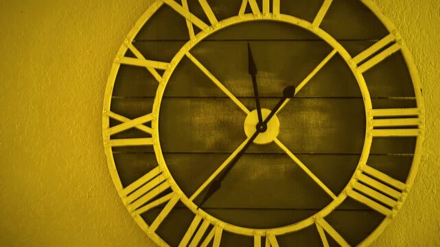 Vintage clock with Roman numerals on wall in warm golden light