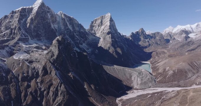 Slow tilt-up aerial drone shot of Chola Tsho Lake and the Khumbu Himalayas in Nepal&rsquo;s Everest region. Reduced snow on high peaks highlights visible environmental change at high altitude.