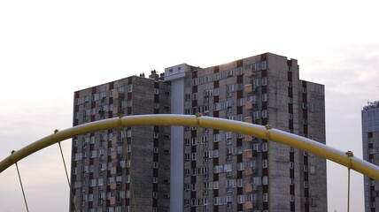 Snow-Capped Yellow Playground Arch with Soviet Panel Block Tower   Winter Urban Poland © Grzegorz
