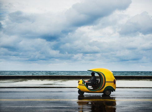 Coco Taxi along the Malecon on a cloudy day, Havana, Cuba