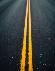 Asphalt road surface texture with bright yellow double lines guiding the way. Abstract perspective of a paved tarmac lane for transportation. Outdoor path, construction detail, traffic direction.