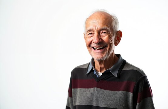 Elderly man smiles widely showing his mouth with no teeth. He wears a striped sweater and is isolated on a white background. Copy space is available on the left side of the image.