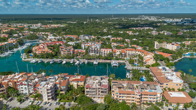Vista a&eacute;rea panor&aacute;mica de marina con yates y desarrollo hotel frente al mar Caribe en destino tropical. Escena que representa turismo de lujo, inversi&oacute;n inmobiliaria y estilo de vida exclusivo e