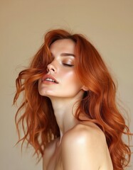 Fototapeta premium Woman with flowing copper hair, eyes closed, head tilted back. Soft studio lighting highlights her smooth skin and radiant complexion. Perfect for beauty and fashion.